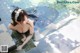 A woman in a black dress is sitting in a pool.