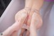 A woman in a pink panties is getting her feet washed in a bathtub.