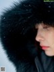 A woman wearing a black fur hat in the snow.