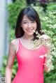 A woman in a pink bathing suit posing for a picture.