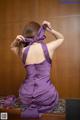 A woman in a purple dress sitting on a table.