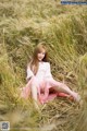 A woman sitting in a field of tall grass.