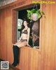 A woman in a leopard print bikini sitting on a window sill.