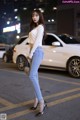 A woman standing in the middle of a city street at night.