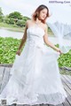 A woman in a wedding dress standing on a wooden bridge.