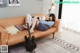 A woman laying on a couch with a guitar.