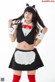 A woman dressed in a maid outfit posing for a picture.