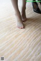 A woman's feet with red nail polish on a wooden floor.